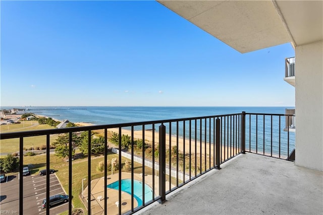 balcony with a water view and a view of the beach