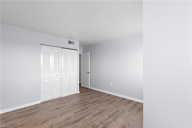 unfurnished bedroom featuring light hardwood / wood-style floors and a closet