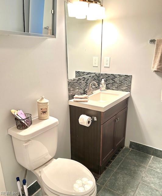 bathroom with vanity, backsplash, and toilet