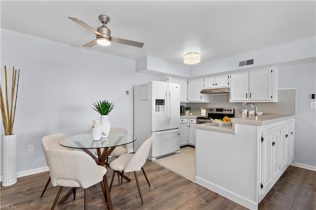 kitchen with dark hardwood / wood-style flooring, white fridge with ice dispenser, white cabinets, and stainless steel electric range oven