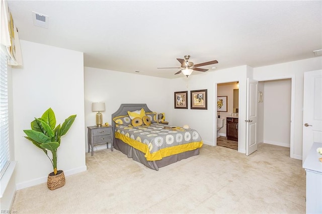 bedroom with light colored carpet, connected bathroom, and ceiling fan