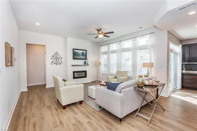 living room with light hardwood / wood-style floors and ceiling fan