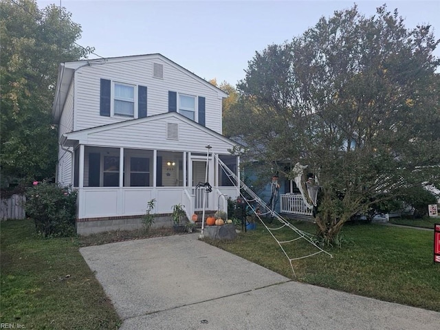 view of front facade featuring a front yard and a sunroom