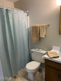 bathroom with a shower with curtain, vanity, toilet, and tile patterned floors