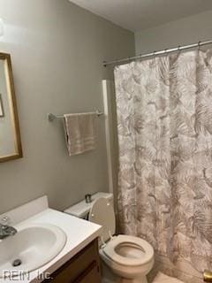 bathroom featuring vanity, toilet, and curtained shower