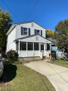 view of front of home with a front lawn and a sunroom