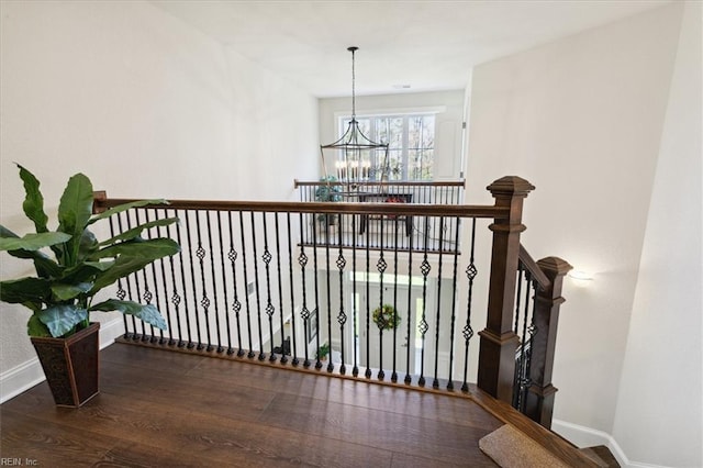 hallway featuring an inviting chandelier and dark hardwood / wood-style floors