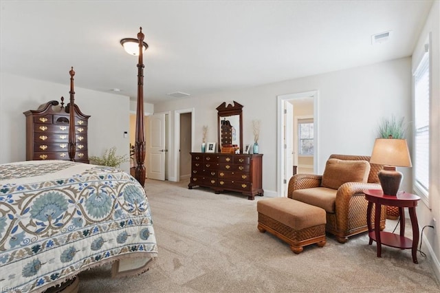 bedroom with light carpet and ensuite bathroom