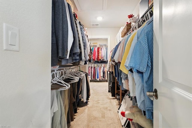 walk in closet featuring light colored carpet