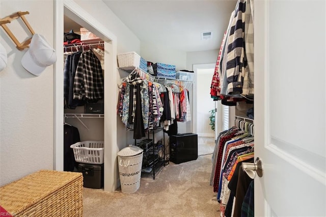 walk in closet featuring light carpet