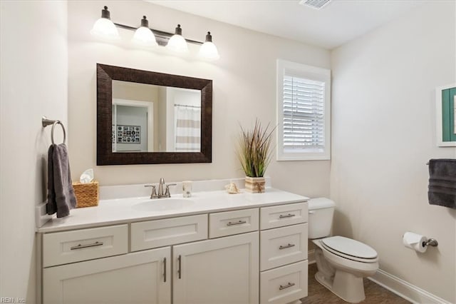 bathroom featuring toilet and vanity