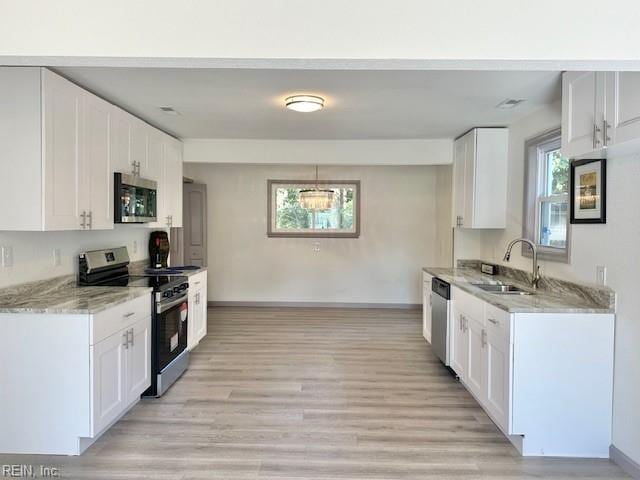 kitchen featuring sink, white cabinets, stainless steel appliances, and light wood-type flooring