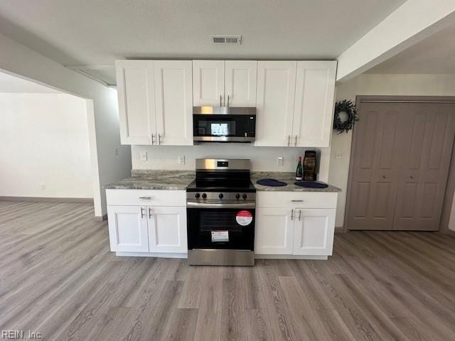 kitchen featuring white cabinetry, stainless steel appliances, and light wood-type flooring