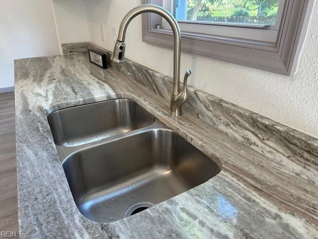 room details with light stone countertops and sink