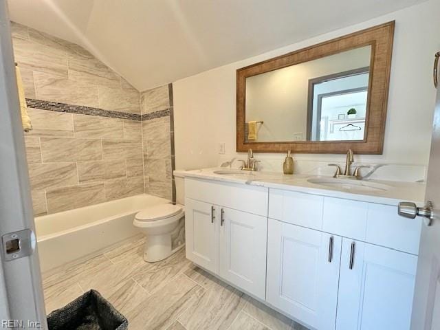 full bathroom with vanity, lofted ceiling, tiled shower / bath combo, and toilet