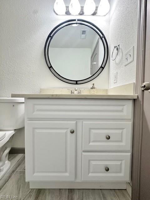 bathroom with vanity, wood-type flooring, and toilet