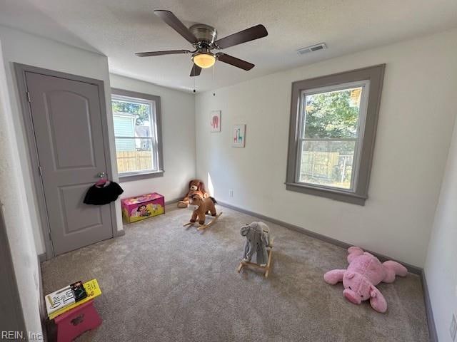 rec room with carpet floors, plenty of natural light, and ceiling fan