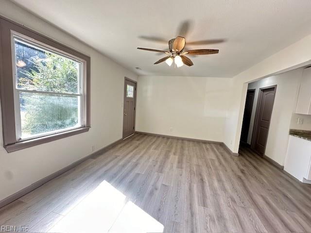 empty room with light hardwood / wood-style flooring and ceiling fan