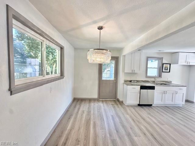 kitchen with white cabinetry, a wealth of natural light, and stainless steel dishwasher