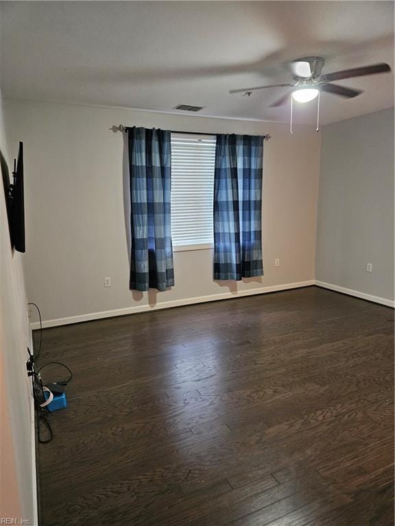 empty room featuring ceiling fan and dark wood-type flooring