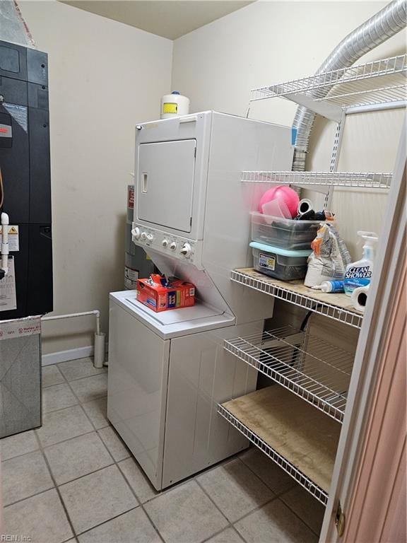 laundry room with light tile patterned floors and stacked washer / drying machine