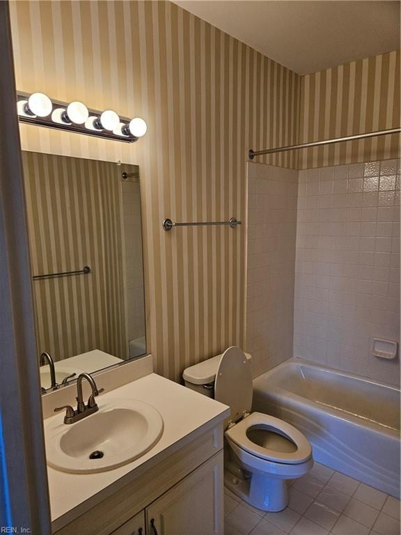 full bathroom featuring toilet, vanity, tile patterned floors, and tiled shower / bath combo