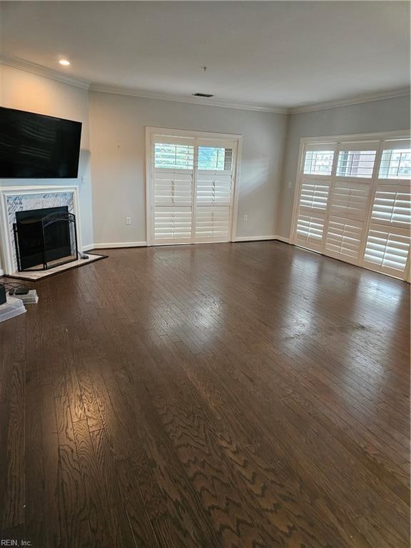 unfurnished living room with crown molding, a fireplace, and dark hardwood / wood-style floors