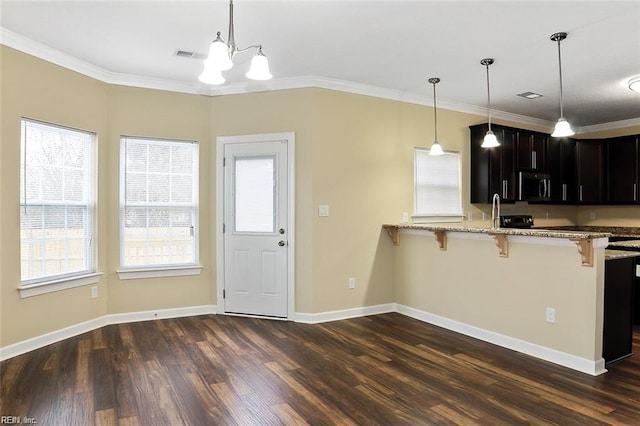 kitchen with a kitchen breakfast bar, kitchen peninsula, ornamental molding, and light stone countertops