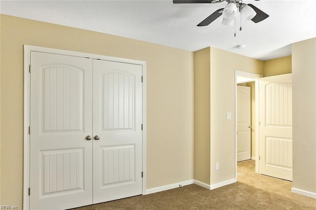 unfurnished bedroom with a closet, ceiling fan, and light carpet