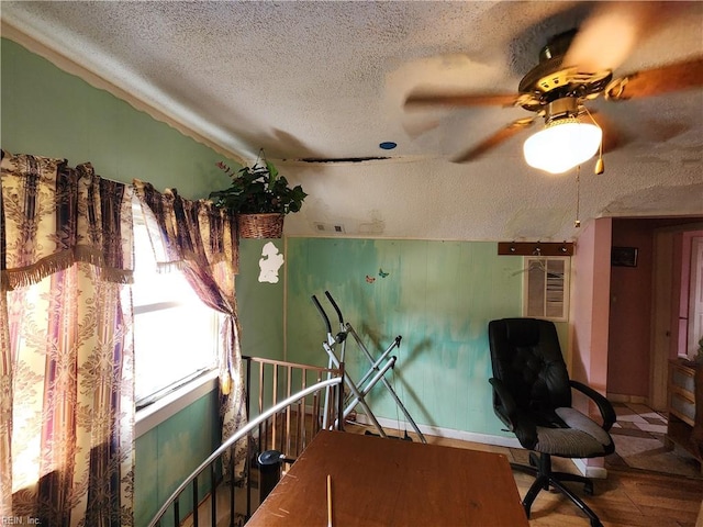 sitting room with a textured ceiling, wood-type flooring, and ceiling fan