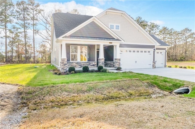 craftsman inspired home featuring a porch, a front lawn, and a garage