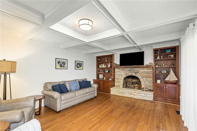 living room featuring beam ceiling, a textured ceiling, wood-type flooring, a fireplace, and coffered ceiling