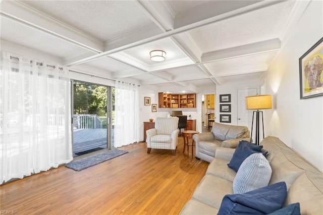 living room with wood-type flooring, a textured ceiling, coffered ceiling, beamed ceiling, and ornamental molding