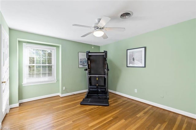 workout area featuring hardwood / wood-style floors and ceiling fan