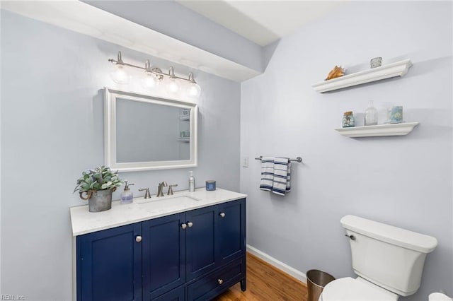 bathroom with vanity, toilet, and wood-type flooring