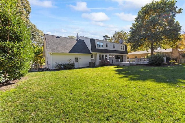 rear view of house featuring central air condition unit, a deck, and a lawn