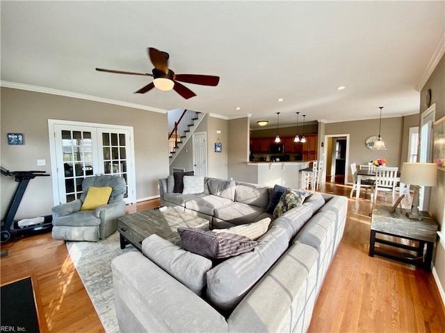 living room with crown molding, light wood-type flooring, and ceiling fan