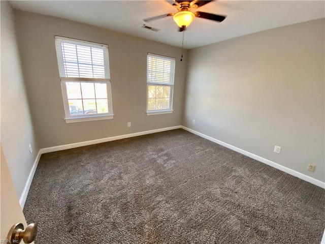 unfurnished room with dark carpet and ceiling fan