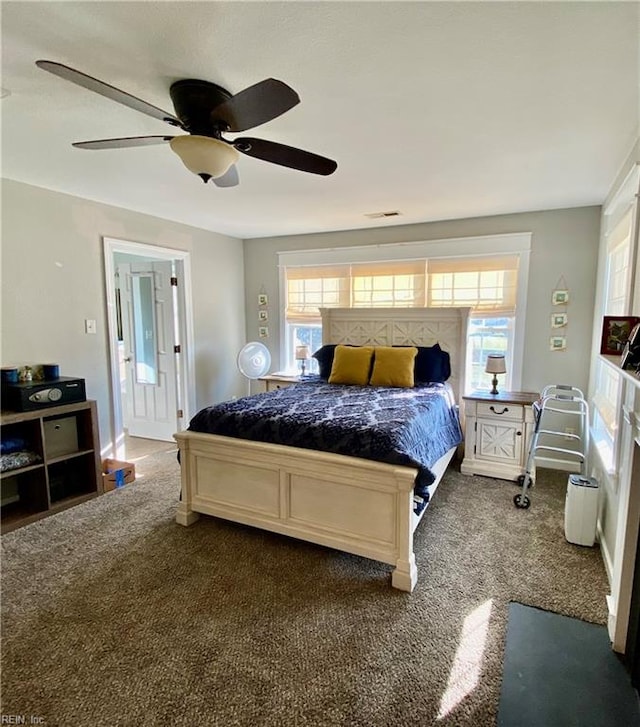 carpeted bedroom featuring ceiling fan and multiple windows