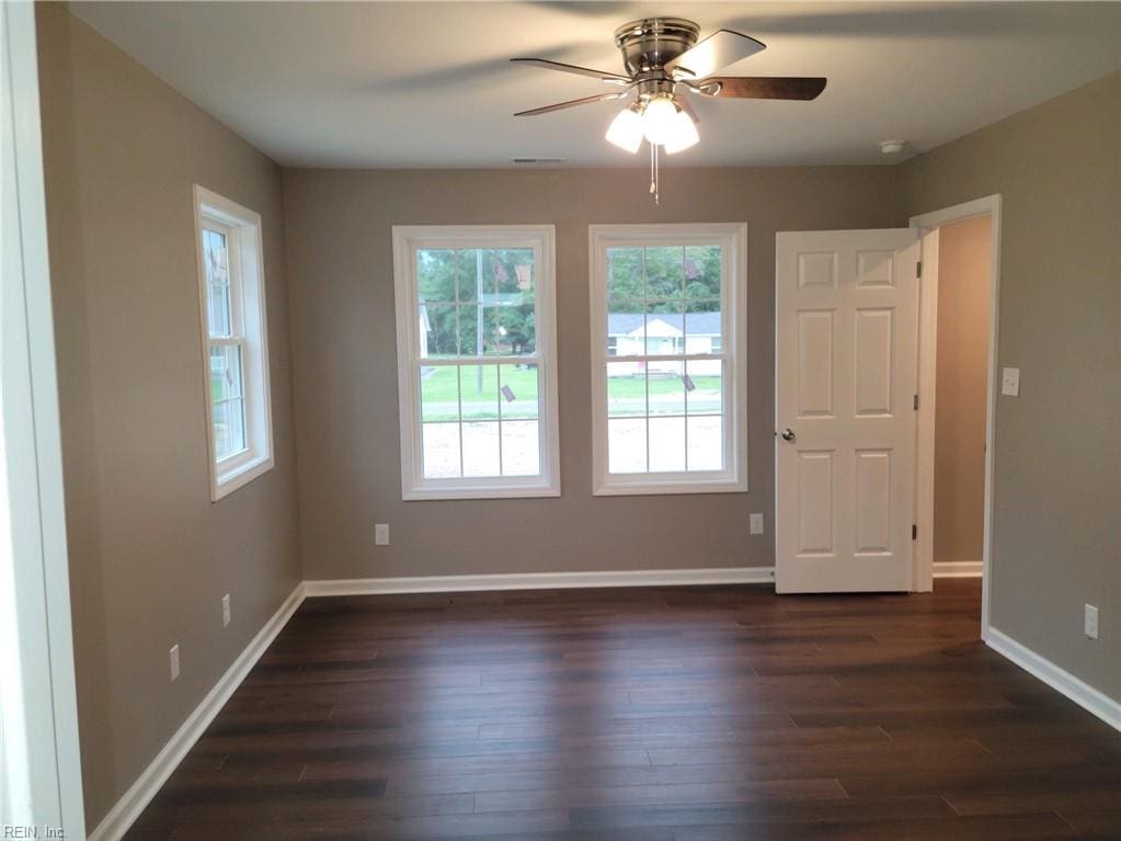 unfurnished room with dark hardwood / wood-style floors and ceiling fan