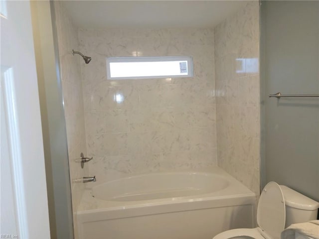 bathroom with tiled shower / bath and toilet