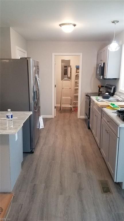 kitchen with appliances with stainless steel finishes, dark hardwood / wood-style floors, and hanging light fixtures