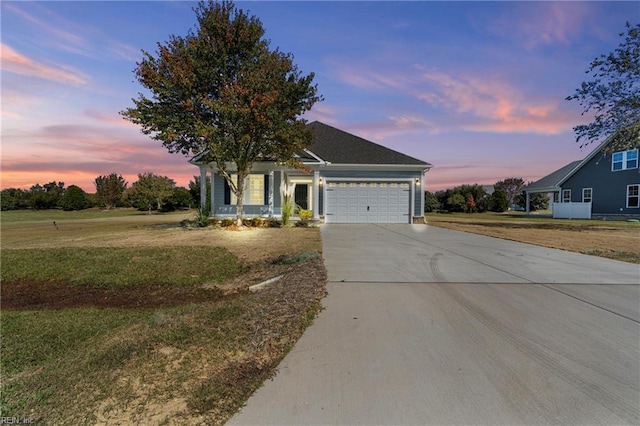 view of front facade featuring a yard, a garage, and covered porch