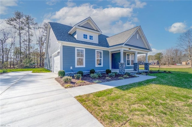 craftsman inspired home featuring covered porch, a garage, and a front lawn