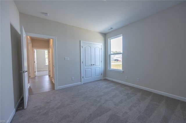 unfurnished bedroom featuring dark carpet and a closet