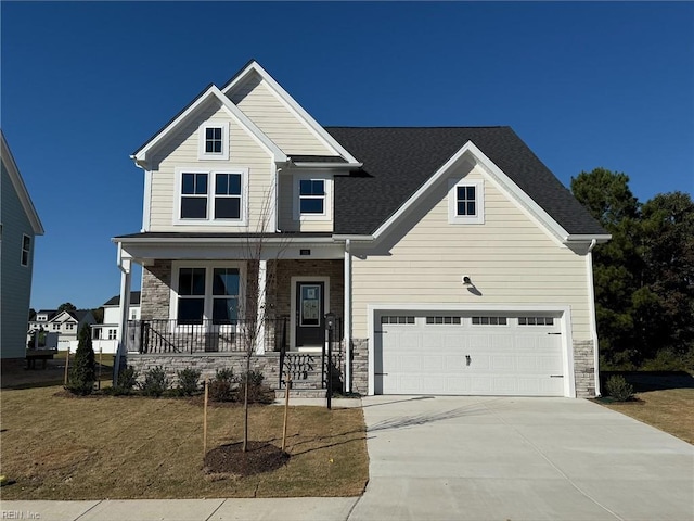 craftsman inspired home with a front lawn, covered porch, and a garage