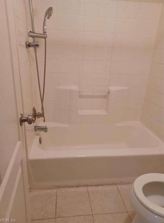 bathroom with toilet, bathing tub / shower combination, and tile patterned floors