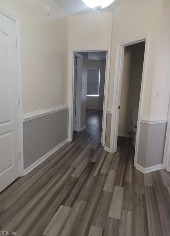 corridor with dark hardwood / wood-style flooring