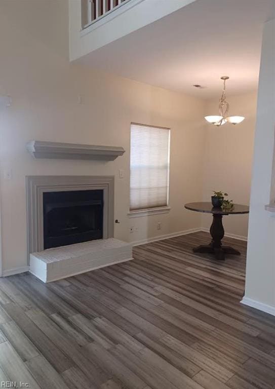 unfurnished living room with a notable chandelier and wood-type flooring