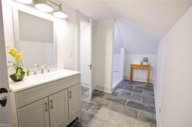 bathroom featuring vanity and lofted ceiling